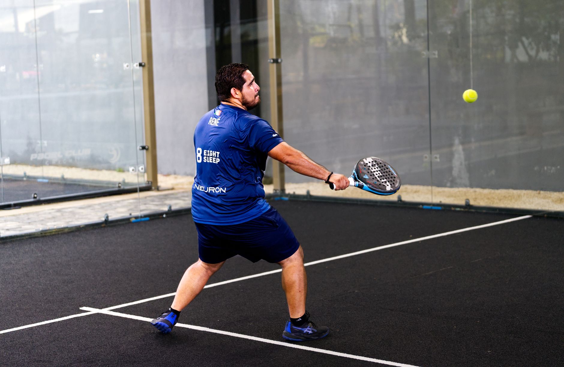 Player in action on an indoor padel court