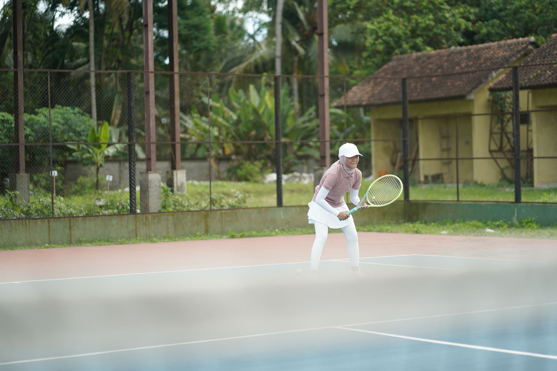 A focused tennis player poised to serve, ready for a one-on-one coaching drill