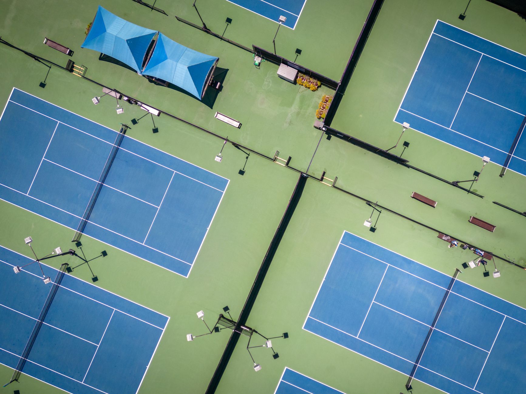Aerial view of multiple blue tennis courts