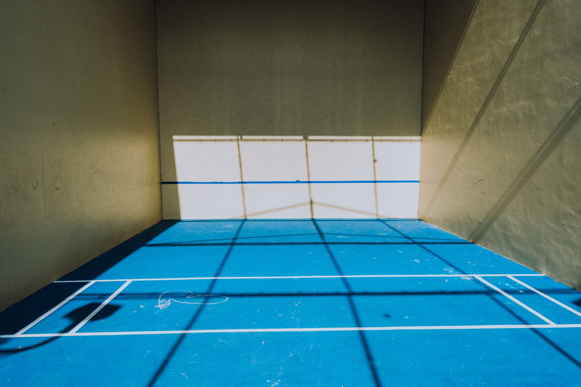 Sunlit pickleball court with shadow patterns
