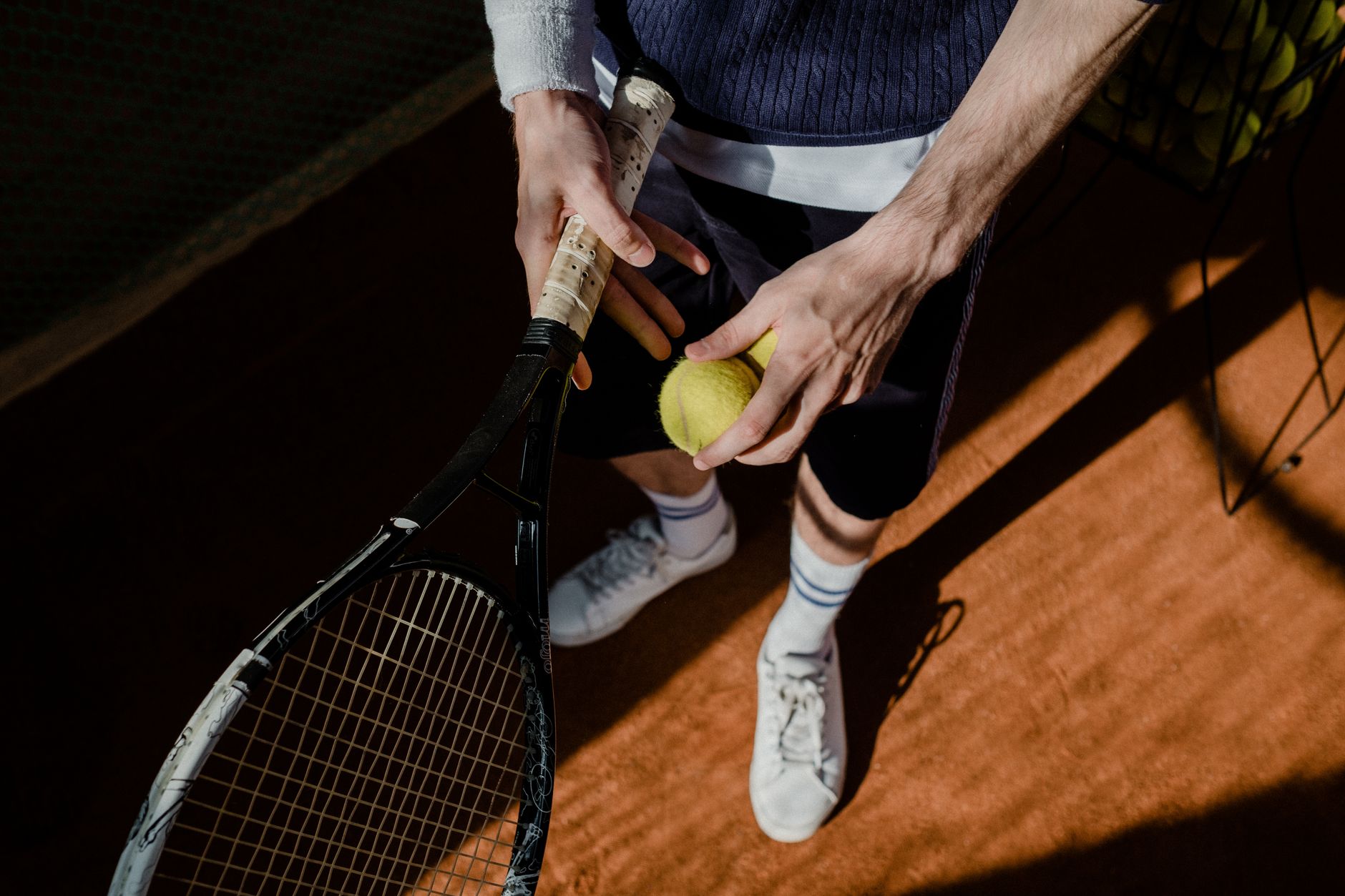 Tennis player preparing to serve on a clay court